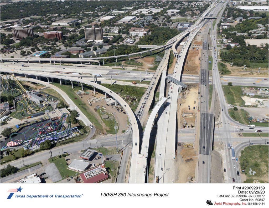 I-30/SH 360 interchange looking down. Highlights demolition of old southbound mainlanes and new bridge structures in use.