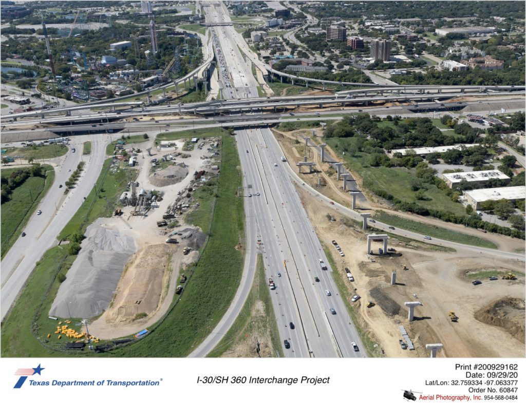 I-30 looking west over Six Flags Dr interchange. Construction of new direct connector to south and north SH 360 shown. Previous westbound exit to Six Flags Dr is removed.