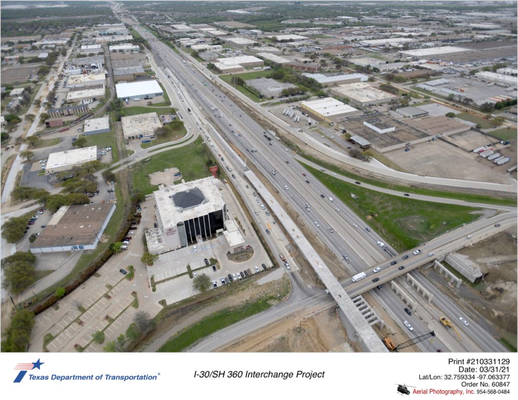 I-30 looking west over Six Flags Dr interchange. New bridge substructure construction for Six Flags Dr underpass is shown.
