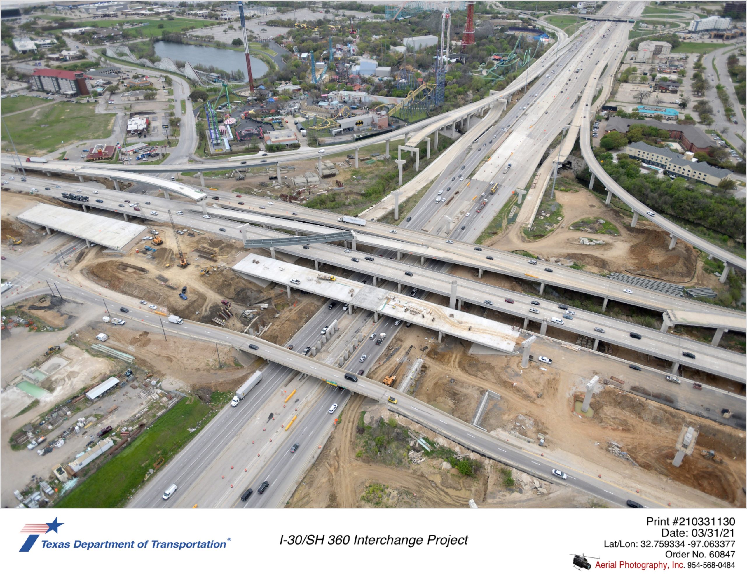I-30 looking west at SH 360 interchange. Focus shows significant progress for SH 360 northbound mainlane bridge over Six Flags Dr and I-30, and bridge substructure work for new SH 360 northbound frontage road bridge over I-30.