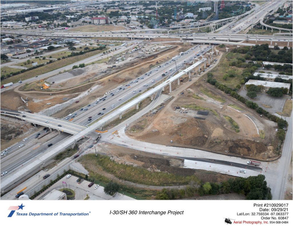 I-30 interchanges with Six Flags Dr and SH 360. Excavation, wall construction, and bridge structure work shown.