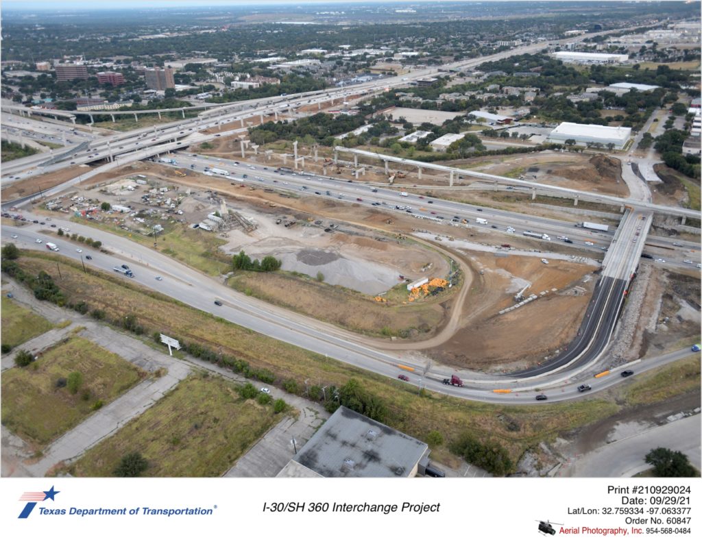 I-30/SH 360 interchange looking northeast over Six Flags Dr. Excavation, wall construction, and bridge structures shown.