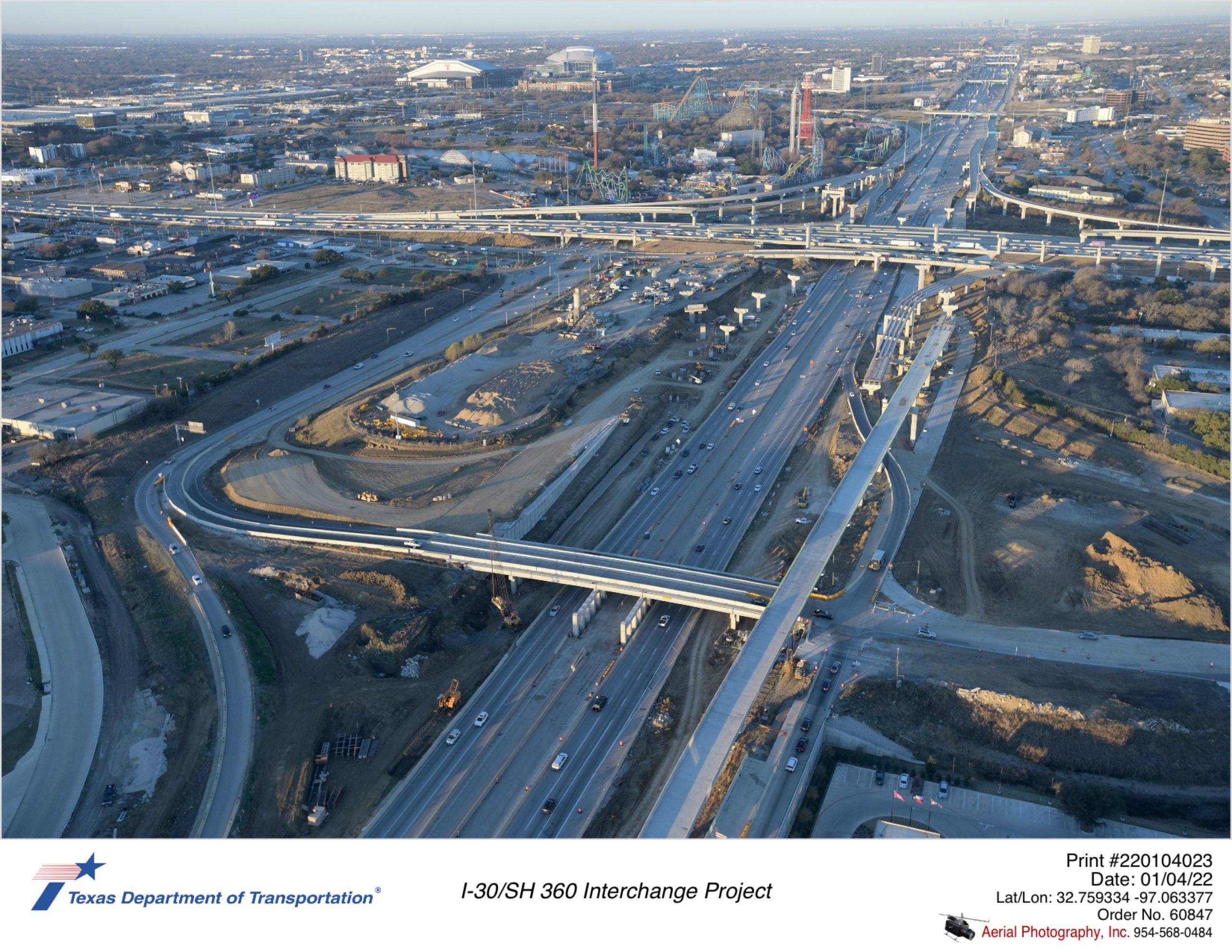 I-30/SH 360 interchange looking southwest over Six Flags Dr. Construction of east portion of Six Flags Dr bridge and direct connector bridge structures shown.