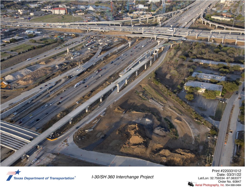I-3o/SH 360 interchange looking southwest over Six Flags Dr. Work on eastbound connector shown progressing.