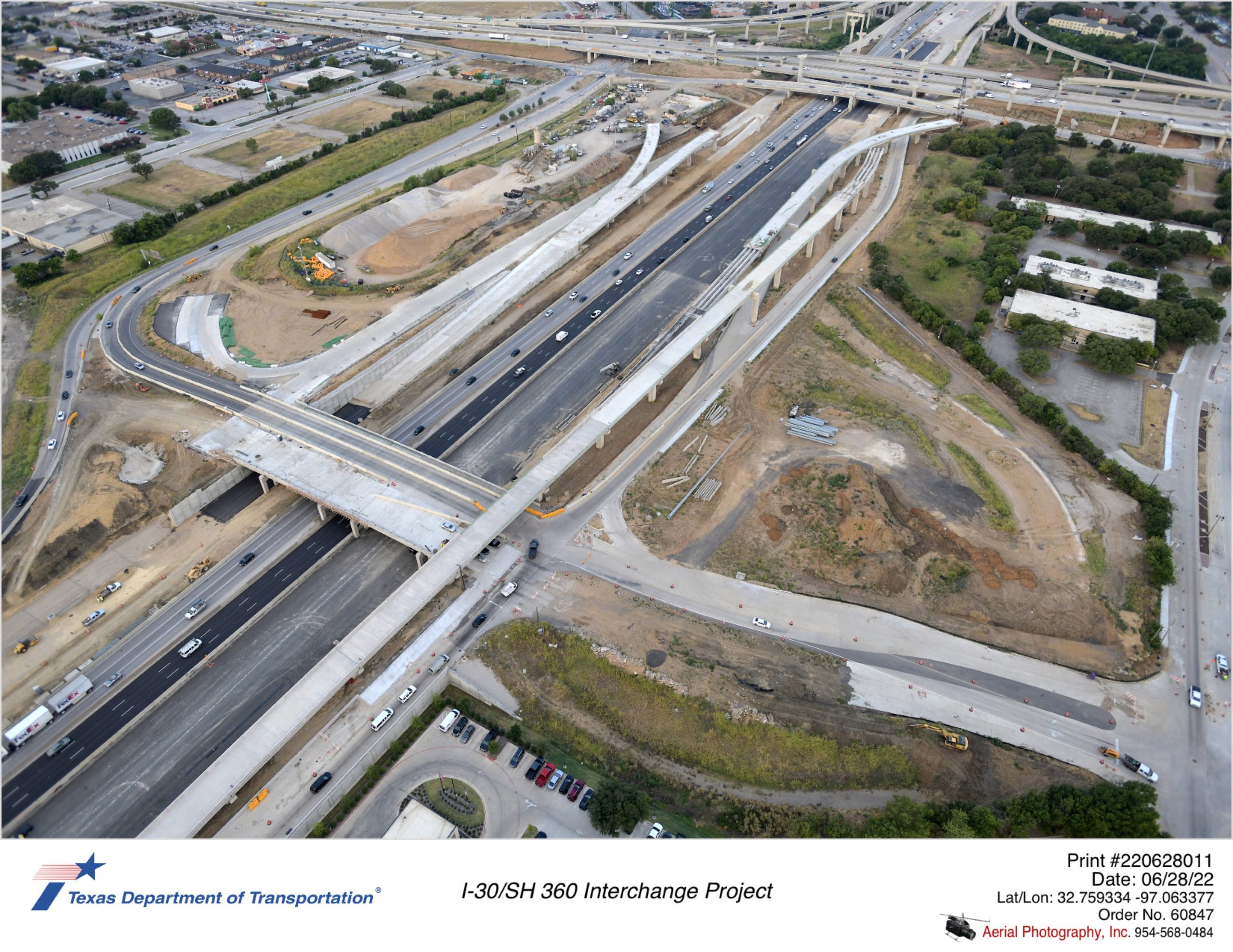 I-30/Six Flags Dr interchange looking southwest. Bridge construction over I-30 and pavement construction between I-30 and Lamar Blvd is shown.